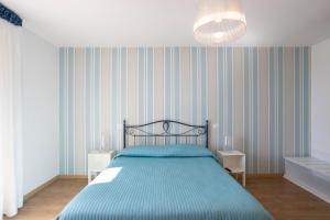 a bedroom with a bed with a blue comforter at Amalfi e Positano Home in Salerno