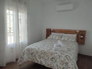 ein Schlafzimmer mit einem Bett mit zwei Schuhen drauf in der Unterkunft Alojamiento Turístico La Cantuérgana in San Martín de Montalbán