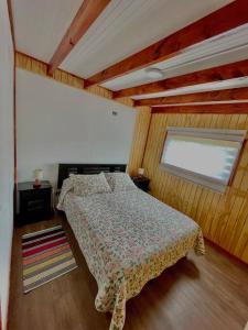 a bedroom with a bed and a window at Cabaña con vista al mar Dalcahue 6 personas in San Javier