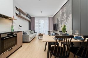 uma sala de estar com um sofá e uma mesa em Ekskluzywny apartament w Porcie Popowice - Fair Rentals em Breslávia