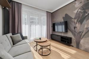 uma sala de estar com um sofá e uma mesa em Ekskluzywny apartament w Porcie Popowice - Fair Rentals em Breslávia