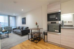 sala de estar con sofá y mesa en Luxury City Centre Apartment (Weekly Booking) en Hull