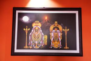una imagen enmarcada de dos ídolos en una pared en Sri Sakthi Residence en Tiruvannāmalai