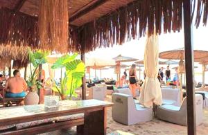 a beach bar with people sitting in chairs and umbrellas at SUN SEA No 5 sea view in Perea
