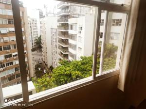 a window with a view of a city at Ipanema Flat in Rio de Janeiro