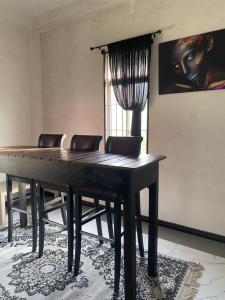 una mesa de ping pong en una habitación con sillas en Black Bird Villa, en Uragasmanhandiya