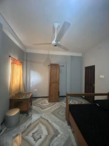 Habitación con ventilador de techo y habitación con mesa. en Black Bird Villa, en Uragasmanhandiya