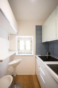 eine weiße Küche mit einem Waschbecken und einem Fenster in der Unterkunft Domo House in Salerno