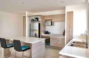 cocina con mesa, 2 sillas y fregadero en M3 Mykonos Elegante y Lujoso Apartment Best of Manta, en Manta