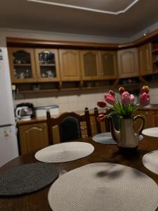 una mesa con platos y un jarrón de flores. en Cottage u Romana, en Yaremche