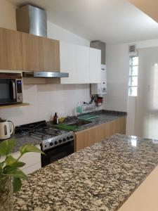 a kitchen with a stove and a counter top at Casa 4 amb y cochera Don Bosco in Córdoba