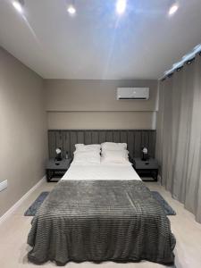 1 dormitorio con 1 cama grande y 2 mesitas de noche en Apartamento em Sapucaia do Sul, en Sapucaia
