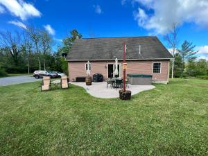 a small house with a patio and a yard at Relaxing Retreat in the Heart of the Finger Lakes!- Dog Friendly and Hot tub in Springwater