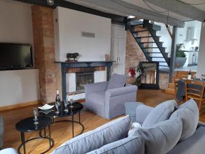 uma sala de estar com dois sofás e uma lareira em Gite du Portalet em Bozouls