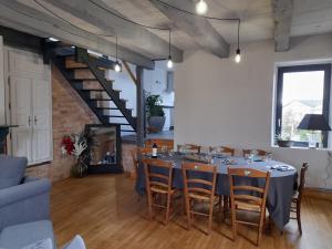 une salle à manger avec une table, des chaises et un escalier dans l'établissement Gite du Portalet, à Bozouls