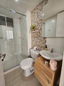 a bathroom with a toilet and a sink and a shower at Apartamento encanto urbano. in Barranquilla