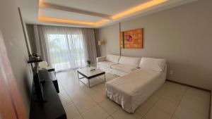 a living room with a white couch and a table at Loft Lodge - Suíte e Sala in Salvador