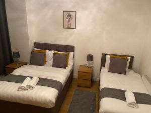 2 aparte bedden in een kamer met 2 lampen bij B&T Pleasure Homes - Southend in Southend-on-Sea