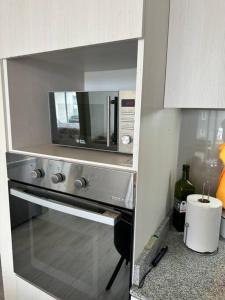 a microwave oven in a cabinet in a kitchen at Departamento full equipado in Viña del Mar