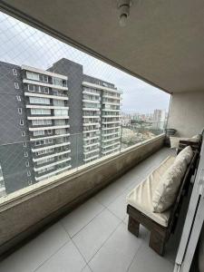 a balcony with a bed and a large window at Departamento full equipado in Viña del Mar