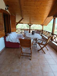 a porch with a table and chairs and a bed at Villa Anta in Skala Kallirakhis
