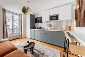 uma cozinha e sala de estar com um sofá e uma mesa em Brand New Luxury Flat in Parc Monceau - Batignolles em Paris
