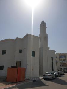 duży biały budynek z wieżą zegarową w obiekcie Seer Furnished Apartments صير للشقق المفروشة w Abu Zabi