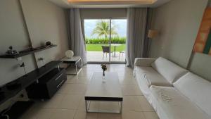 uma sala de estar com um sofá branco e uma mesa em Loft Lodge - Suíte e Sala em Salvador