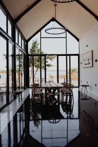 - une salle à manger avec une table, des chaises et des fenêtres dans l'établissement Lira Boutique Lodge, à Thohoyandou