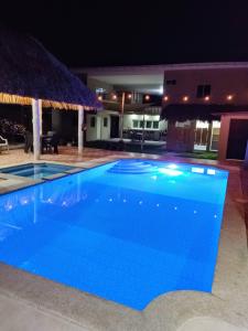 a large blue swimming pool at night at Rancho Del Oso Tuerto in Marcelino