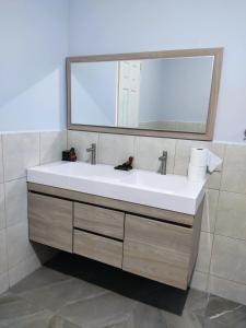 a bathroom with a white sink and a mirror at Rancho Del Oso Tuerto in Marcelino