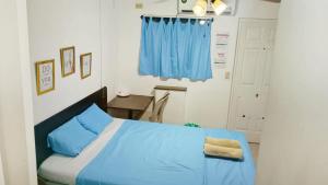 um quarto com uma cama azul e uma cortina azul em Orison Hostels Managua em Manágua