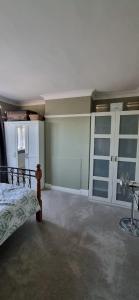 een slaapkamer met een bed en een aantal glazen kasten bij Stunning 3 bedroom semi detached house! in Goodmayes