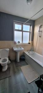 een badkamer met een toilet, een wastafel en een bad bij Stunning 3 bedroom semi detached house! in Goodmayes