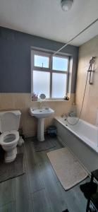 e bagno con servizi igienici, lavandino e vasca. di Stunning 3 bedroom semi detached house! a Goodmayes