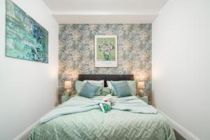 a bedroom with a bed with a teddy bear on it at Niru Experience Royal Deluxe 4BD 2BA Apt in London