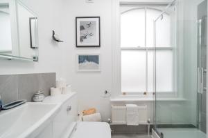 een badkamer met een douche, een toilet en een wastafel bij Niru Experience Royal Deluxe 4BD 2BA Apt in Londen