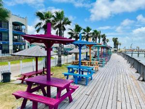 a row of picnic tables and benches on a boardwalk at Krsna's Castle (Hunt's Castle) in Rockport