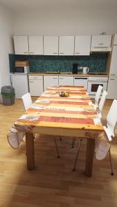 una gran mesa de madera en una cocina con armarios blancos en Familientreff im Grünen mit Tennisplatz en Bad Freienwalde
