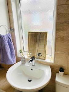 y baño con lavabo, espejo y aseo. en Cozy Retreat Haven, en Liverpool