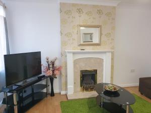 a living room with a fireplace and a tv at Perfect Stay Manchester in Wythenshawe
