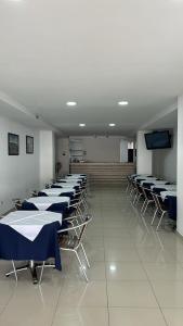 une chambre avec des rangées de tables et de chaises et une télévision dans l'établissement hgo hotel, à Cali