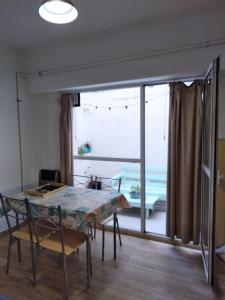 a dining room with a table and a large window at Inmejorable ubicación frente al mar in Puerto Madryn