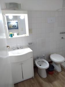 a white bathroom with a sink and a toilet at Inmejorable ubicación frente al mar in Puerto Madryn