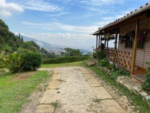 uma estrada de terra ao lado de uma casa numa colina em La casita en la Estrella em La Estrella