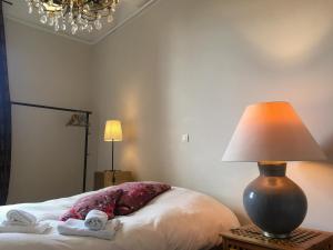 サン・ポール・トロワ・シャトーにあるLa Terrasseのベッドルーム1室(ランプ、タオル付)