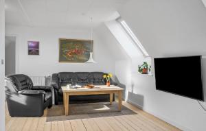 sala de estar con sofá, mesa y TV en 1 Bedroom Beautiful Apartment In Thyborn, en Thyborøn
