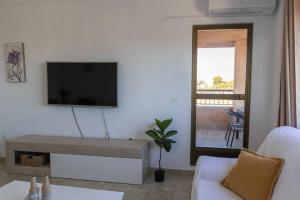ein Wohnzimmer mit einem Flachbild-TV an der Wand in der Unterkunft Playa Mucha Vista apto, Parking, Piscina, AC in El Campello