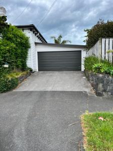 eine Garage mit einer Garagentür auf einer Einfahrt in der Unterkunft Grey Lynn House Auckland in Auckland