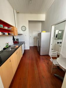 eine Küche mit einem Kühlschrank und Holzböden in der Unterkunft Grey Lynn House Auckland in Auckland